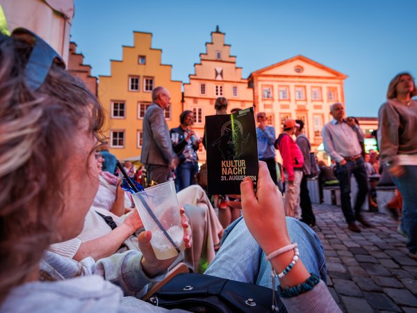 Kulturnacht-Folder vor Häusern auf dem Marktplatz.